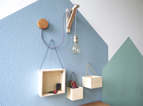 Kästchen mit Bastelutensilien hängen an einer Wand